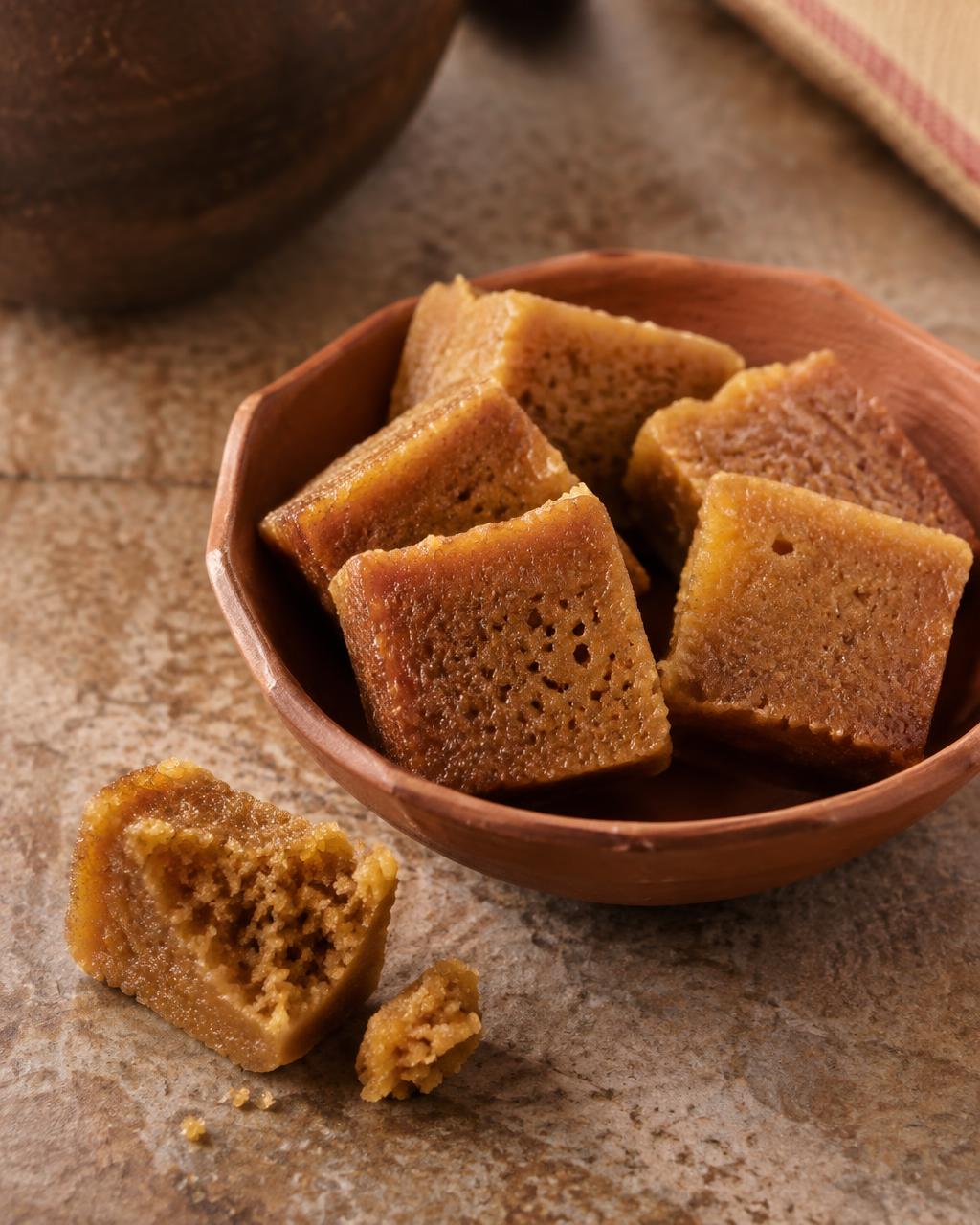 Jaggery Mysore Pak squares in a terracotta katori